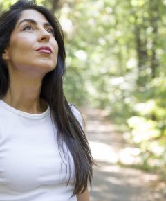 Young  woman breathing fresh air in the summer park