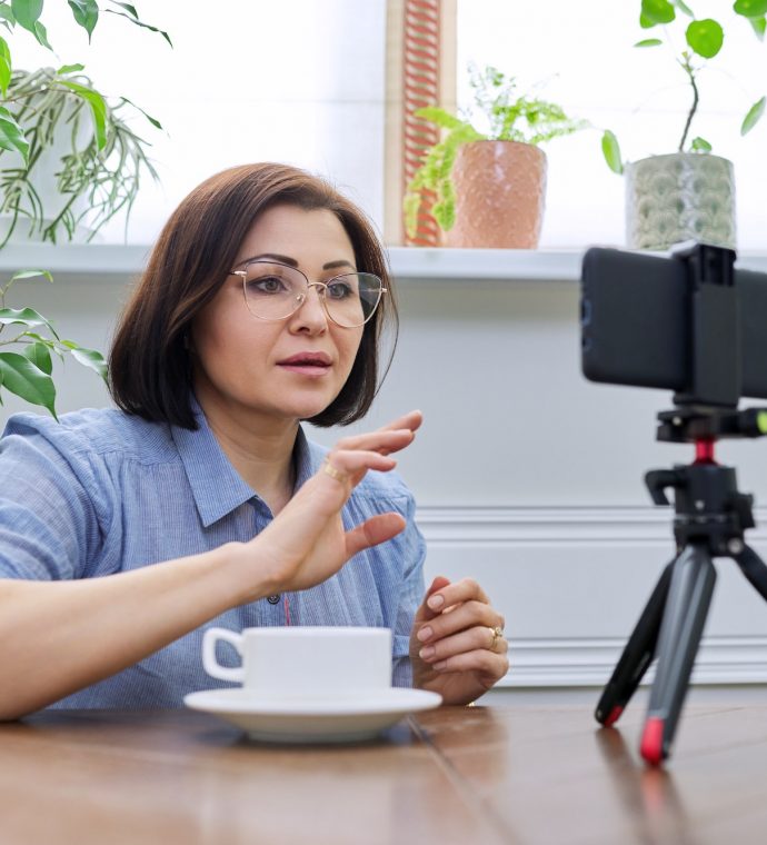 Woman teacher, mentor, psychologist looking at webcam of smartphone